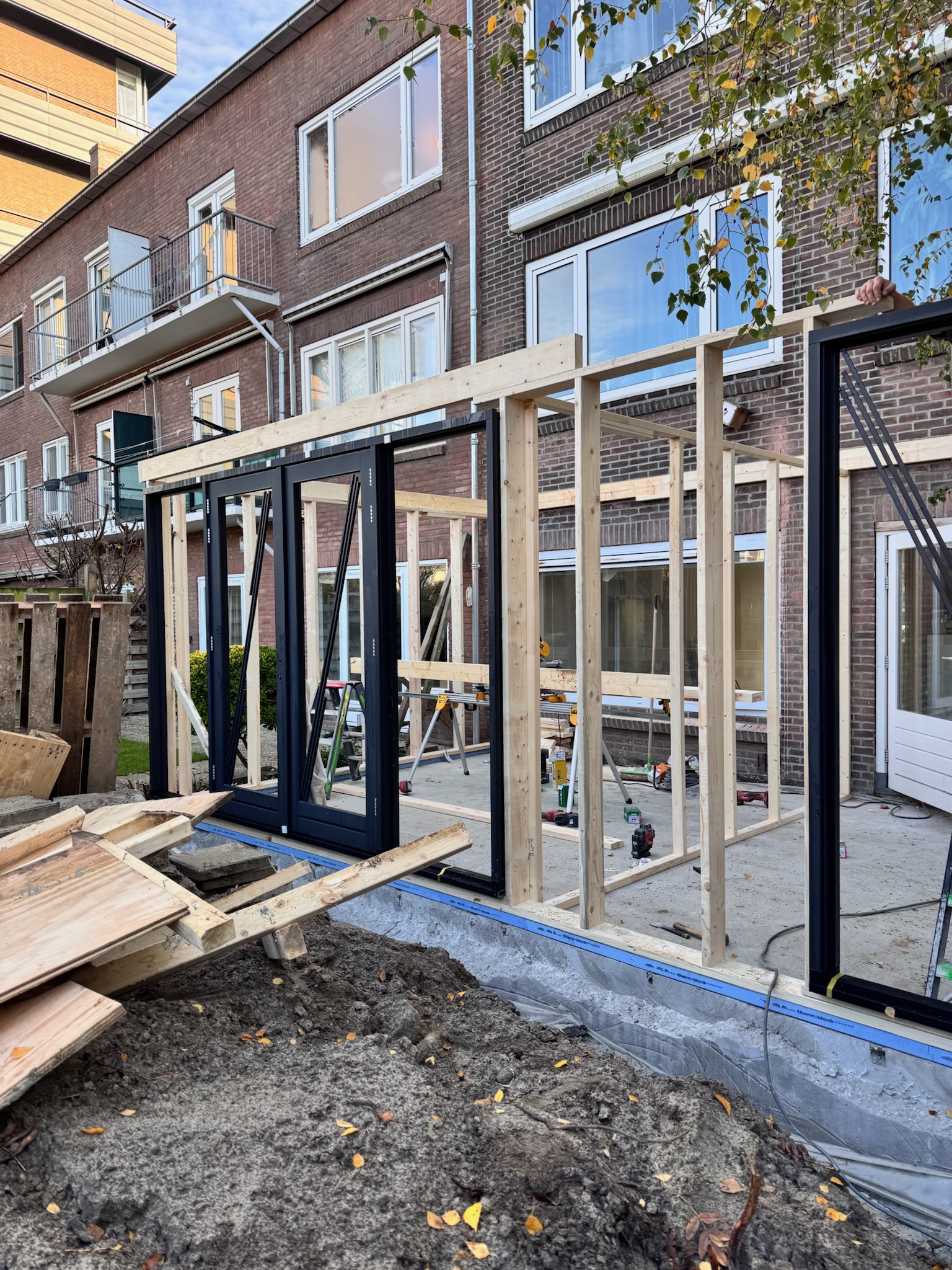 Aanbouw met zwarte kozijnen in opbouw