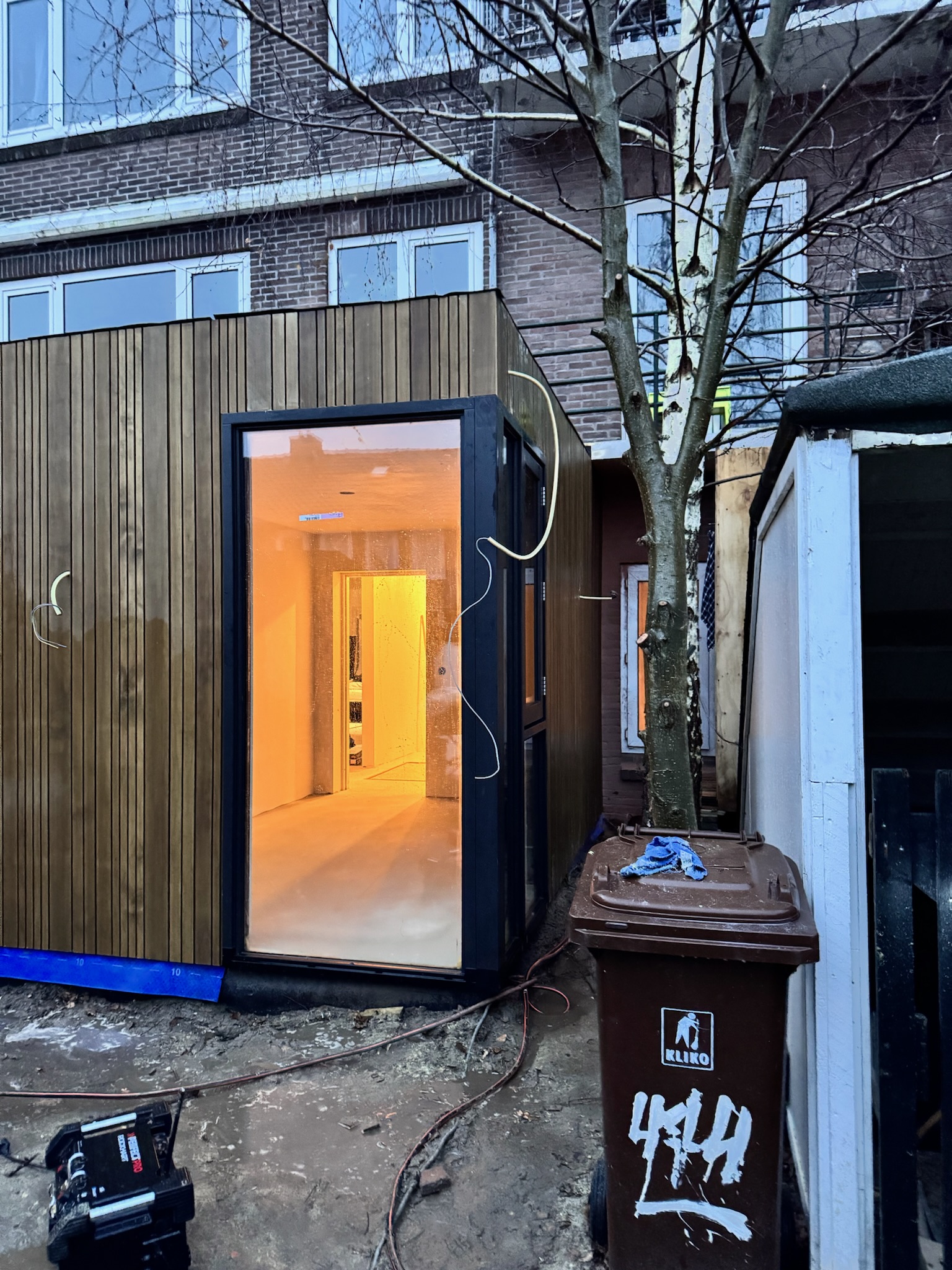 Uitbouw Utrecht bij avond, geel licht door glaspui